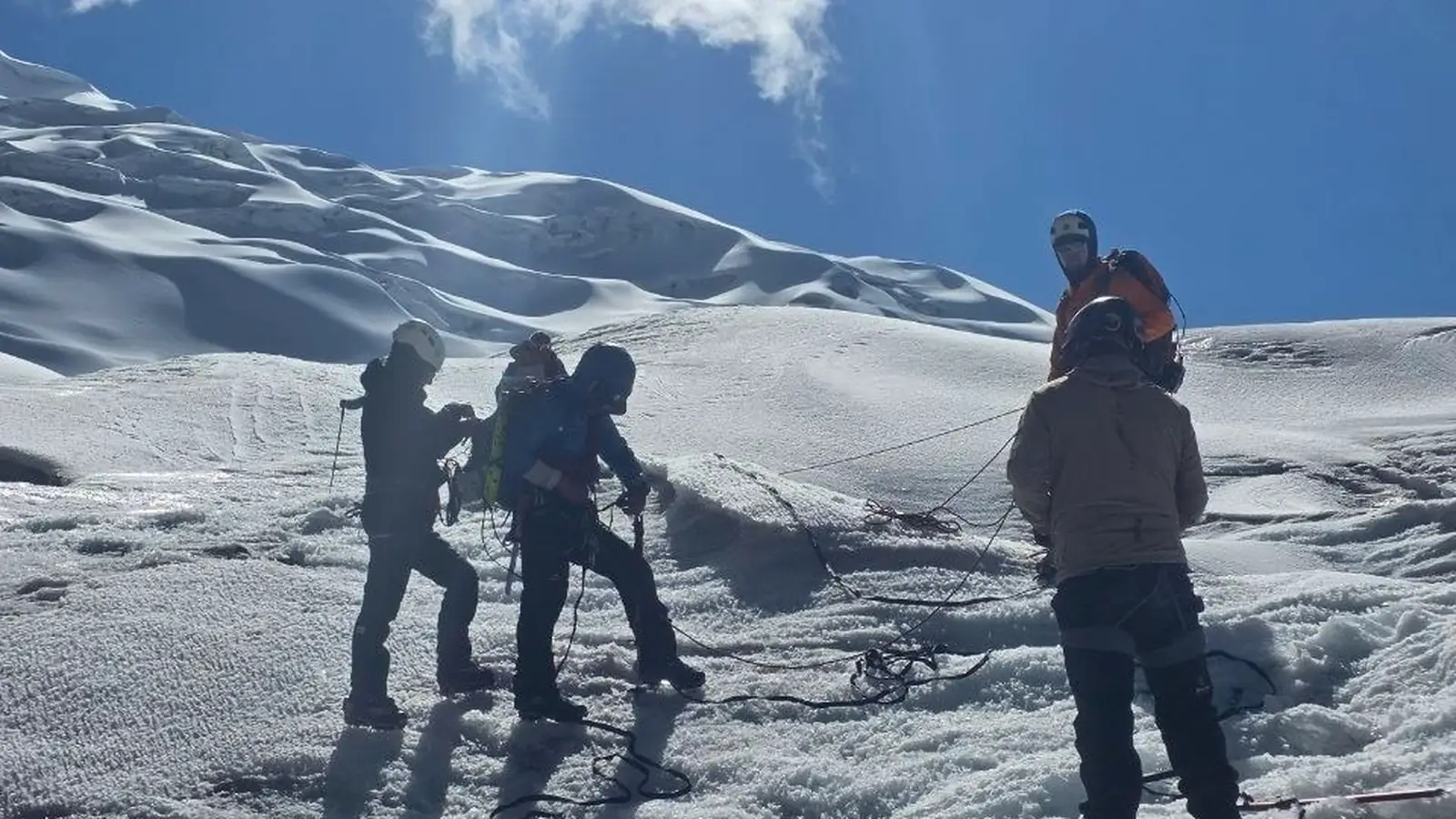 Equipo de campo sobre una superficie glaciar bajo cielo despejado